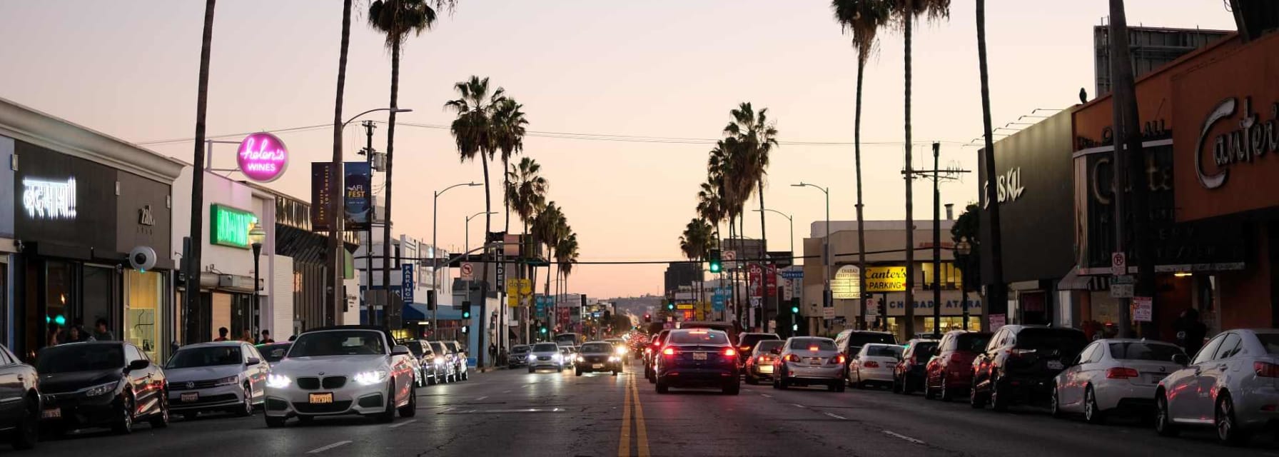 a large road in los angeles with palm trees on either side