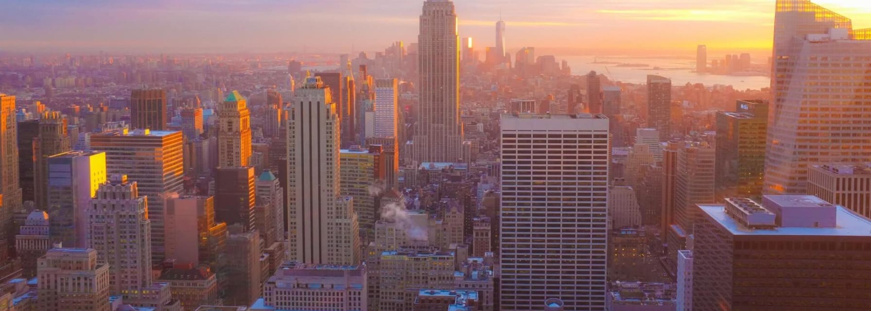 birds eye view of the empire state building and the rest of new york city while the sun is setting