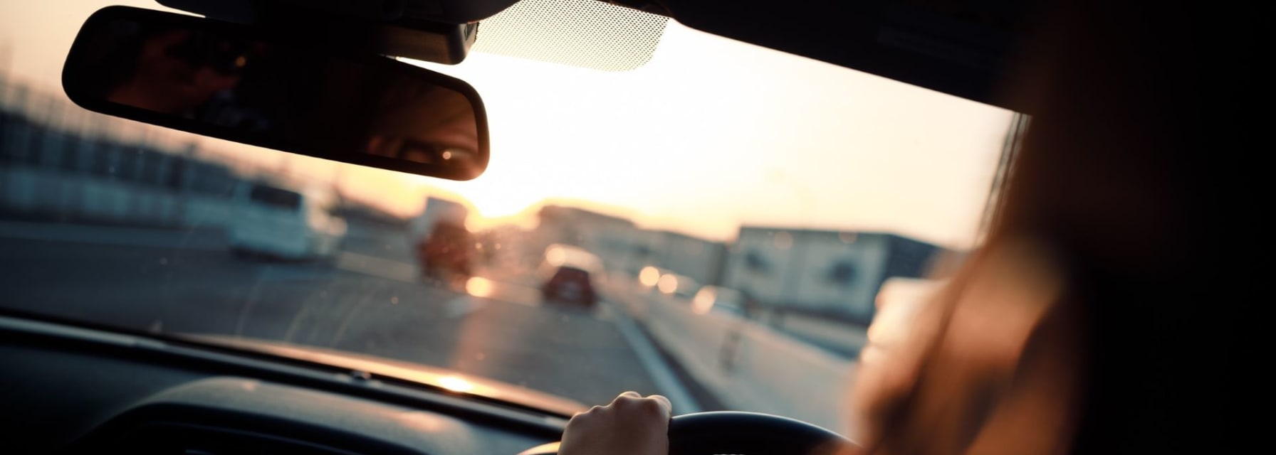 Photo of a man driving from inside the car.