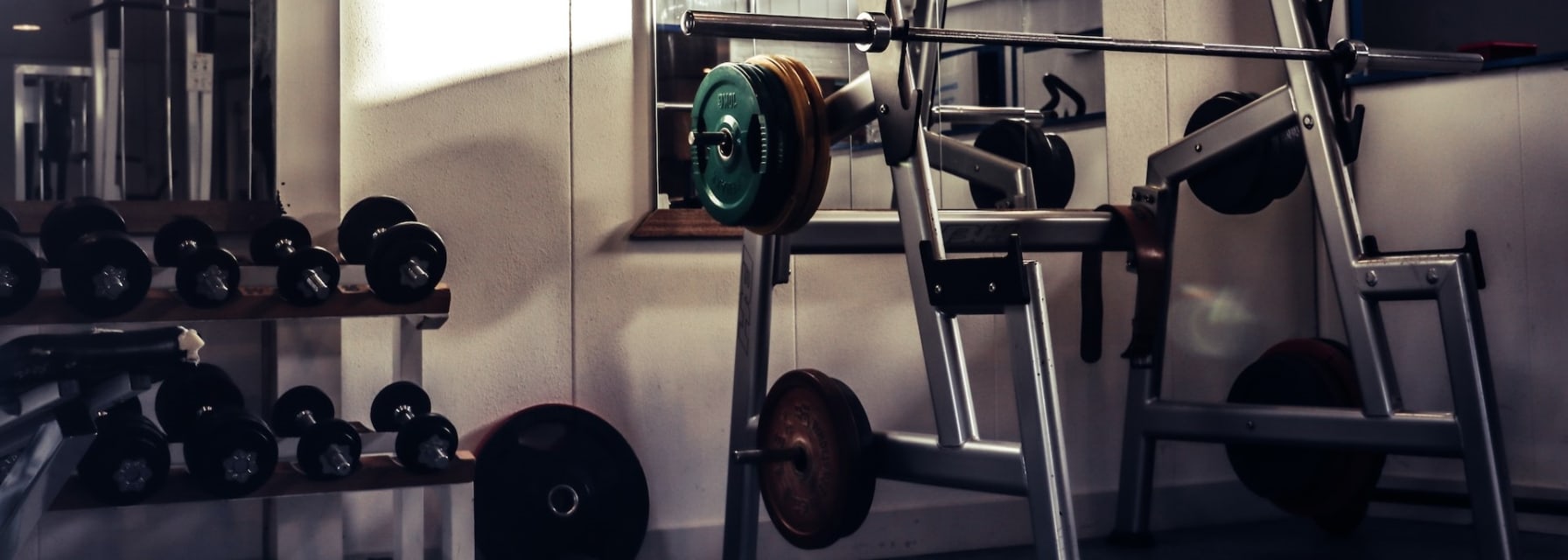 A dumbbell rack and weight station in a gym.