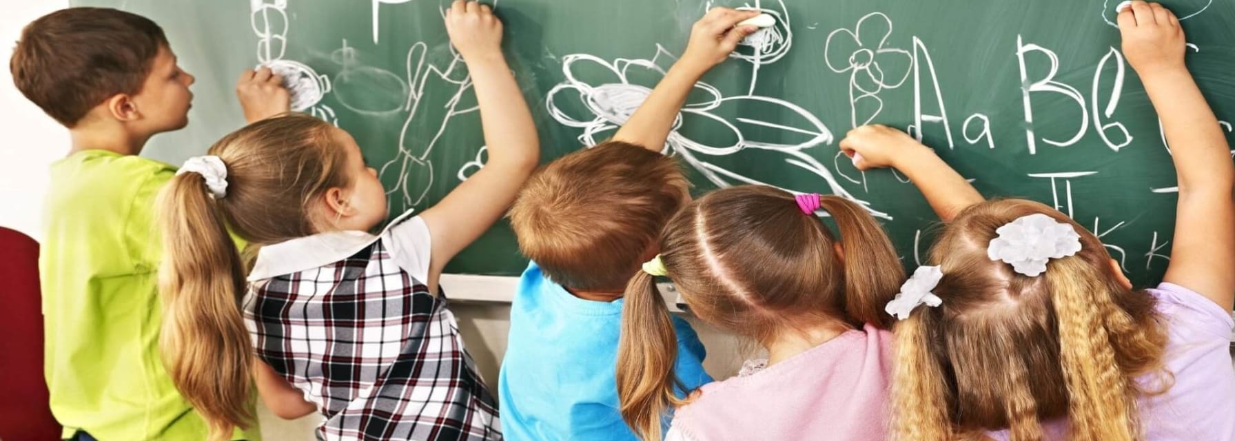 international schools Boston children writing on chalkboard at school