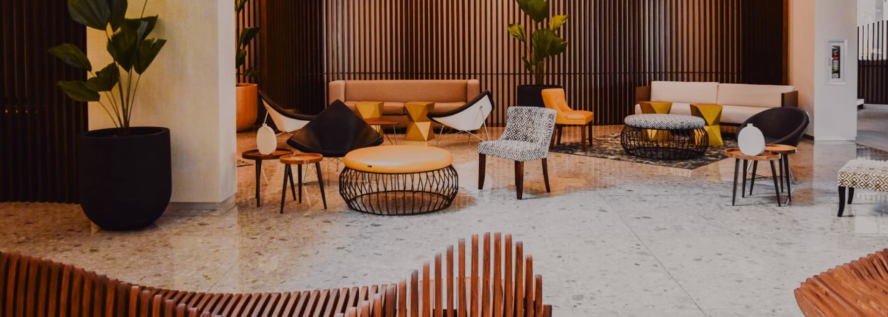 a modern lounge area with wooden seating and decor, sophisticated lighting and plants