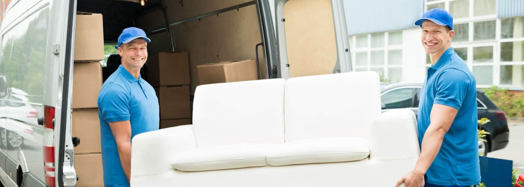 Furniture donation DC and two movers carrying a couch to a van