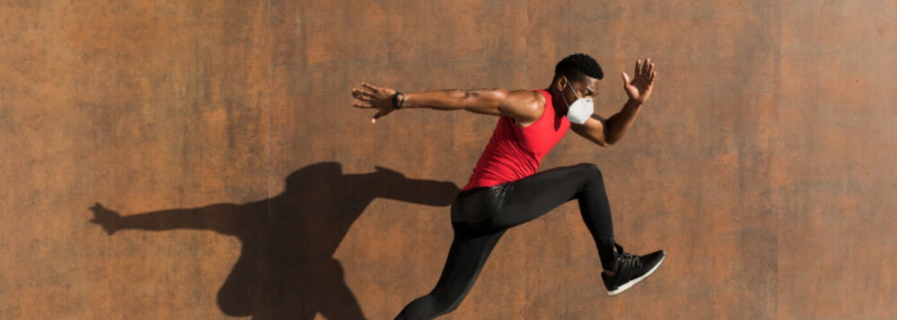 a man is jumping/running while wearing a protective mask