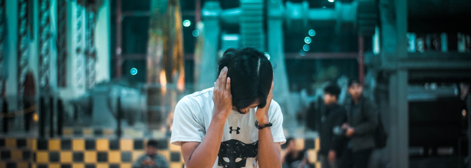 man is reacting to a loud noise by closing his ears