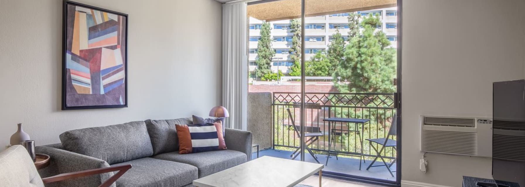 a quiet westwood living room with greenery outside the window