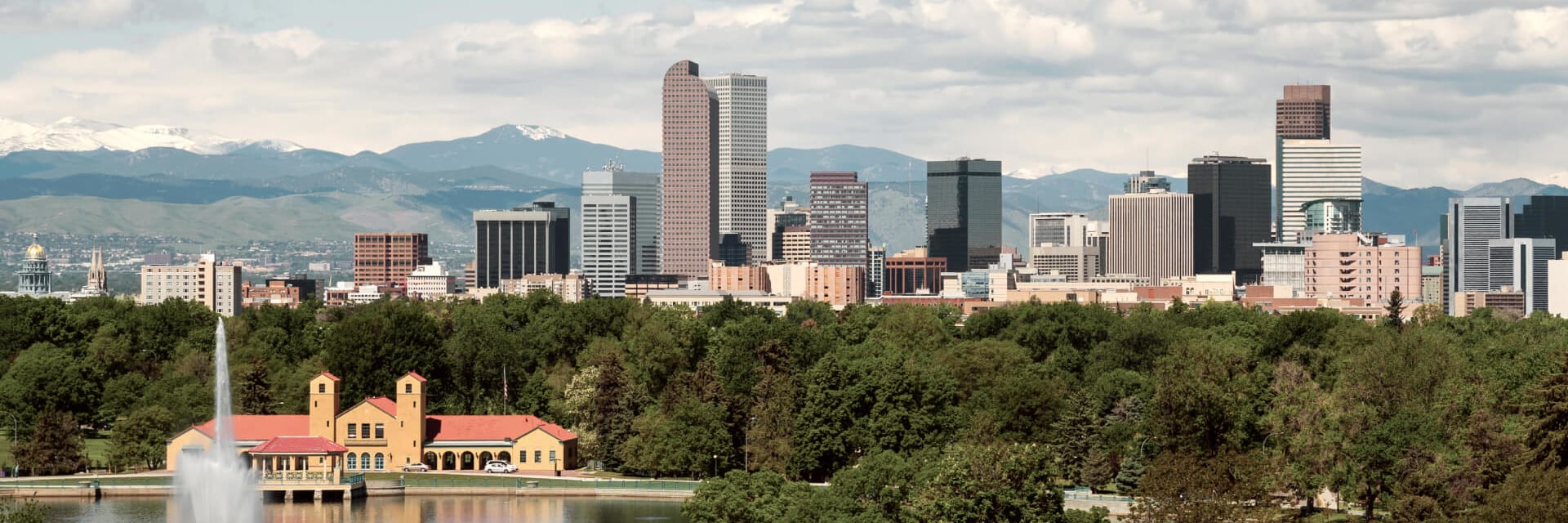 A wide shot of downtown Denver with a park in the foreground and skyscrapers in the distance.