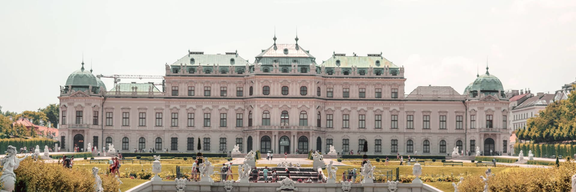 A garden with statues and an 18th century building in Vienna, Austria.