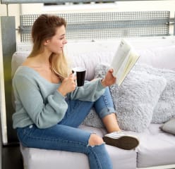 Woman reading a book on a balcony