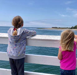 Two girls watch surfers in Malibu