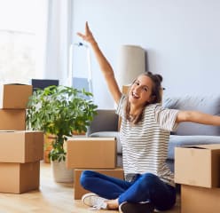 Female student with boxes in apartment