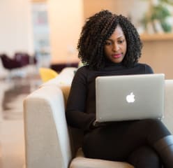 woman working on her laptop sitting on a couch