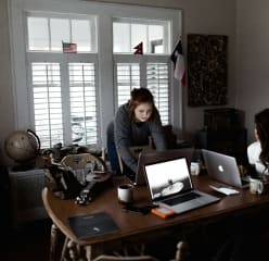 2 students working on their laptops in their student apartment