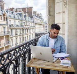 Man working on balcony at a Blueground apartment in Paris