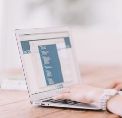 a woman works on a laptop in a home office