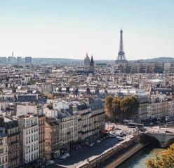 the paris skyline on a cloudy day with the eiffel tower in the background