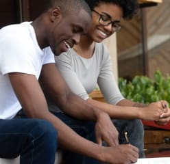 couple smiling while signing a lease agreement