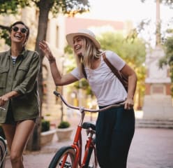 blueprint blueground best cities for young people happy women walking on city street with bikes