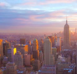 birds eye view of the empire state building and the rest of new york city while the sun is setting
