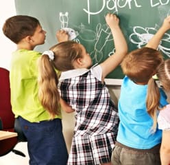 international schools Boston children writing on chalkboard at school