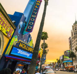 Hollywood Californi at sunset with an orange sky above buildings and lights