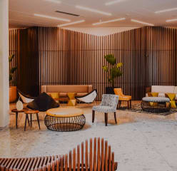 a modern lounge area with wooden seating and decor, sophisticated lighting and plants