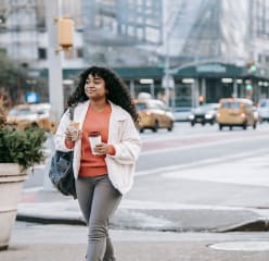 young woman walking in new york city with coffee
