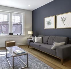 furnished apartment living room with a dark grey accent wall a marble coffee table and a TV
