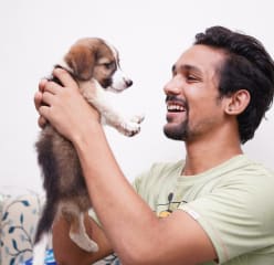 A man hugs his puppy