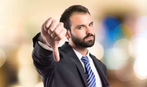 Man in suit with thumb pointing down