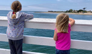 Two girls watch surfers in Malibu