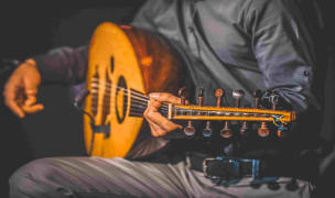 A man holding a traditional string instrument.