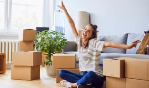 Female student with boxes in apartment