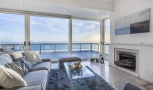 Spacious living room with modern furniture and a big fireplace in Palaio Faliro, Athens featuring a stunning sea view