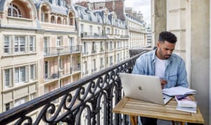 Man working on balcony at a Blueground apartment in Paris