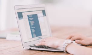 a woman works on a laptop in a home office