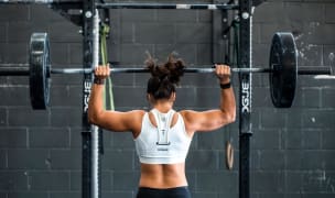 A woman lifts weights at the gym