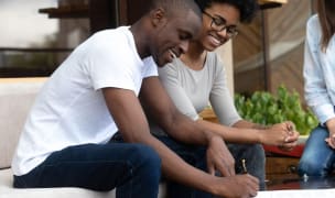 couple smiling while signing a lease agreement
