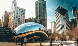 The giant "bean" statue in downtown Chicago with skyscrapers in the distance.