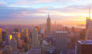 birds eye view of the empire state building and the rest of new york city while the sun is setting