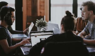 People sitting in the table of a co-working space and working on their laptops