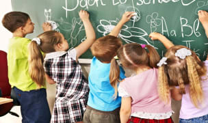 international schools Boston children writing on chalkboard at school