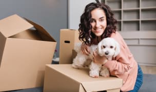 Pet-friendly apartment and lady with a small dog in an apartment with boxes