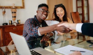 man shaking hands with realtor after closing deal on new home