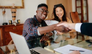 man shaking hands with realtor after closing deal on new home