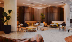 a modern lounge area with wooden seating and decor, sophisticated lighting and plants