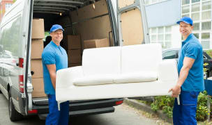 Furniture donation DC and two movers carrying a couch to a van