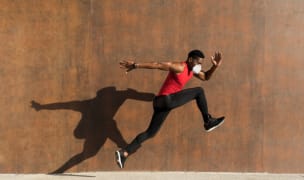 a man is jumping/running while wearing a protective mask