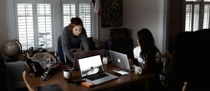 2 students working on their laptops in their student apartment