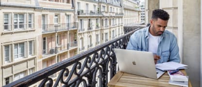 Man working on balcony at a Blueground apartment in Paris